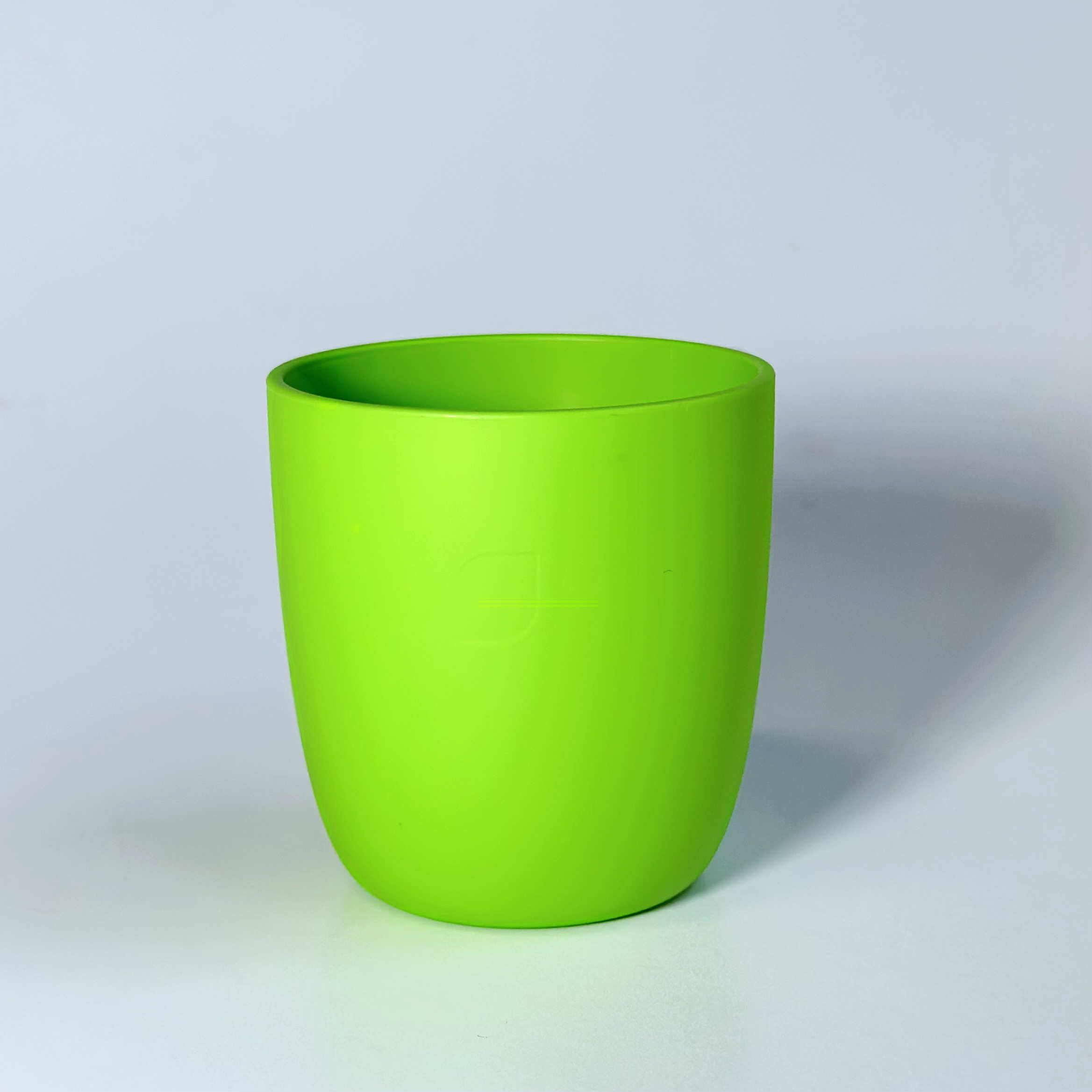 Grüner Trinkbecher aus Biopolymer auf weißem Hintergrund