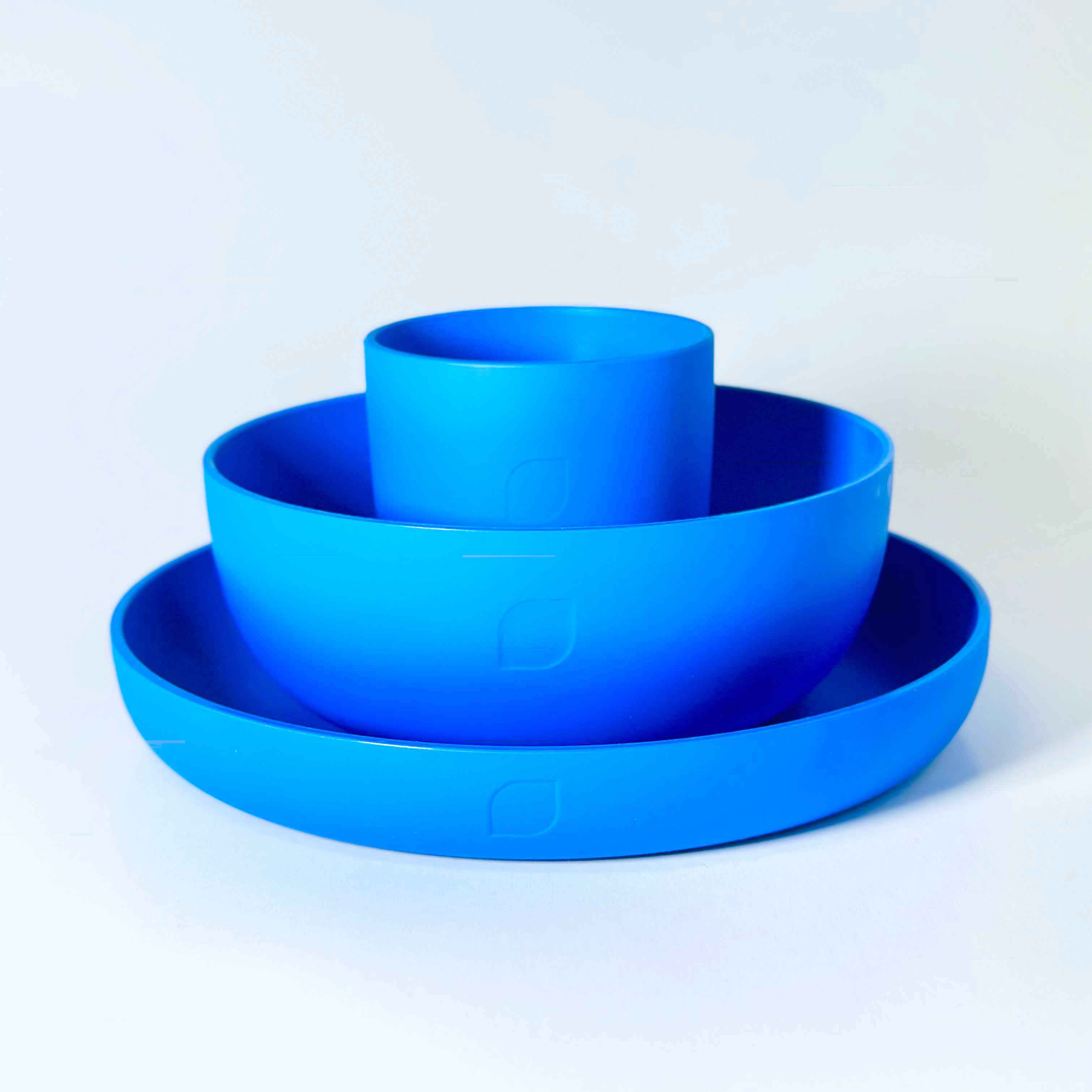 Plastikgeschirr-Set bestehend aus Teller, Schälchen und Becher in Blau auf weißem Hintergrund.