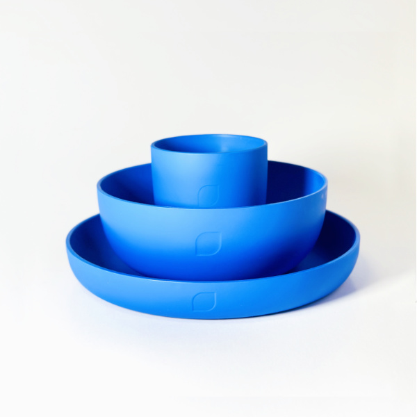 Plastikgeschirr-Set bestehend aus Teller, Schälchen und Becher in Blau auf weißem Hintergrund.