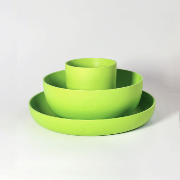 Plastikgeschirr-Set bestehend aus Teller, Schälchen und Becher in Grün auf weißem Hintergrund.